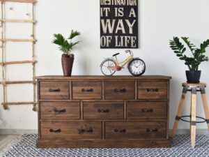 Rustykalna drewniana komoda z dziewięcioma szufladami i dekoracjami w stylu vintage